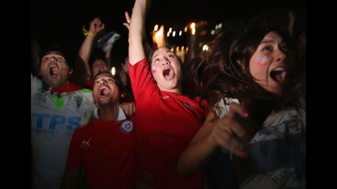 Chilean team fans react as they watch their team score against Australia on a giant screen showing the match at Copacabana Beach in Rio de Janeiro, Brazil.