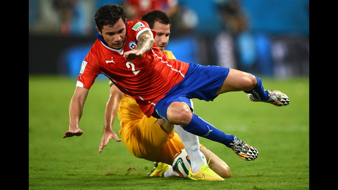 Eugenio Mena of Chile is brought down during the game.