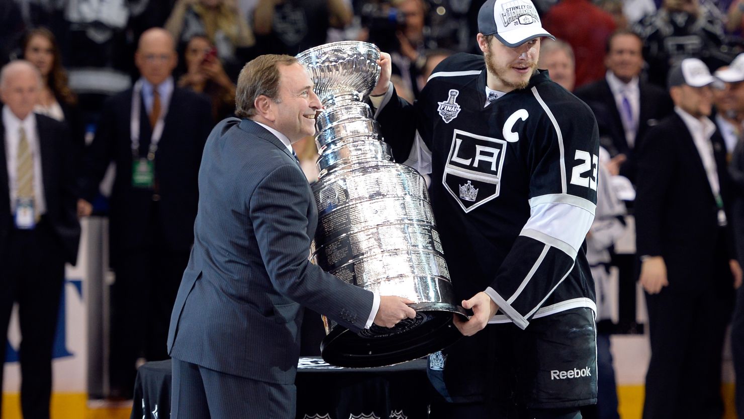 Dustin Brown of the L.A. Kings poses with NHL Commissioner Gary Bettman after the Kings won the Stanley Cup.