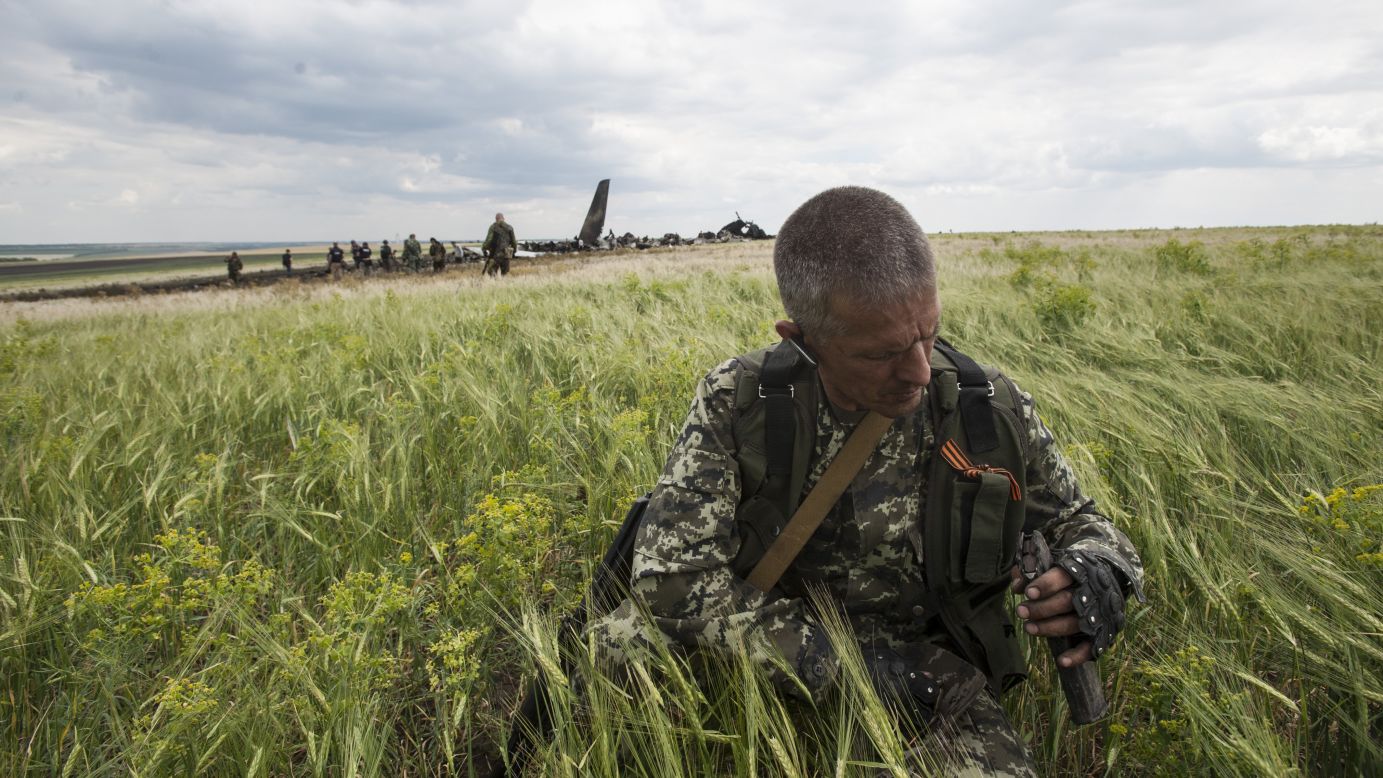 A pro-Russian fighter collects ammunition from the debris of the downed military aircraft on June 14.
