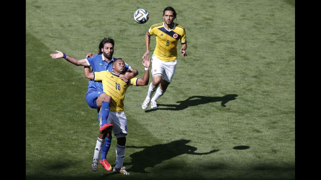 Greece's forward Georgios Samaras, left, vies with Colombia's defender Juan Camilo Zuniga, whose teammate  Abel Agui watches on. 