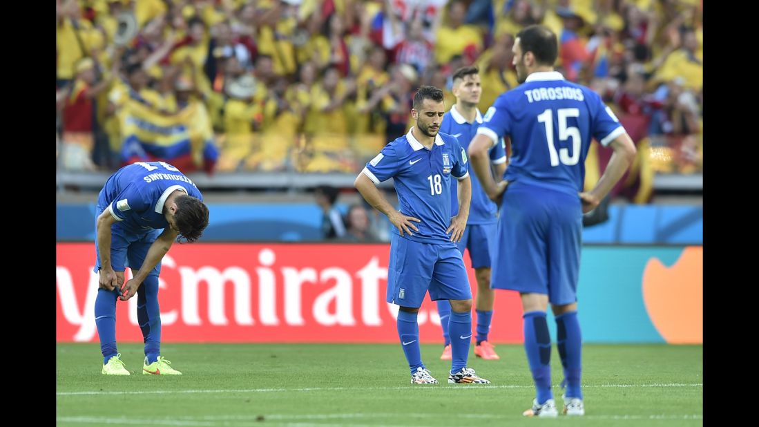 Greece forward Ioannis Fetfatzidis, second left, and defender Vasilis Torosidis, right, react after conceding the third goal in time added on.
