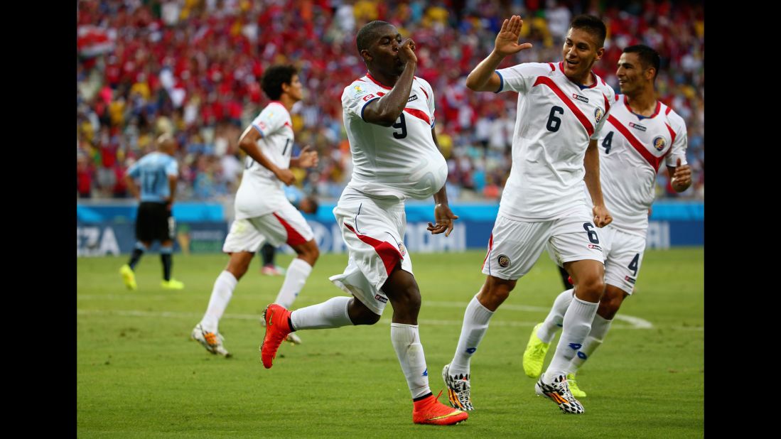 Joel Campbell of Costa Rica, left, celebrates scoring his team's first goal with the ball under his jersey as teammates Oscar Duarte, center, and Michael Umana run on.