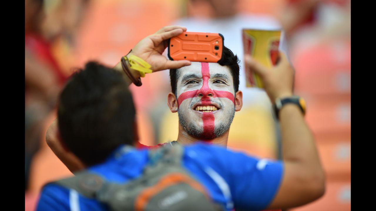 An England supporter takes pictures prior to the start of the match. 