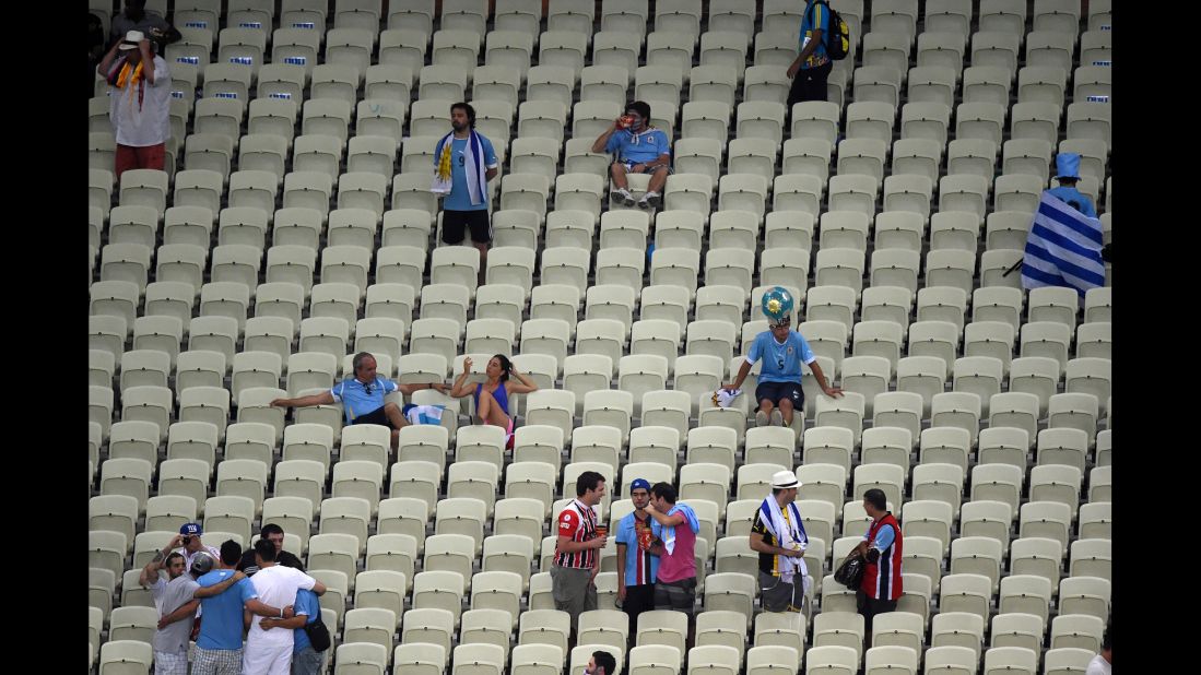 Uruguay fans, in blue, are pictured after their team's defeat to Costa Rica.
