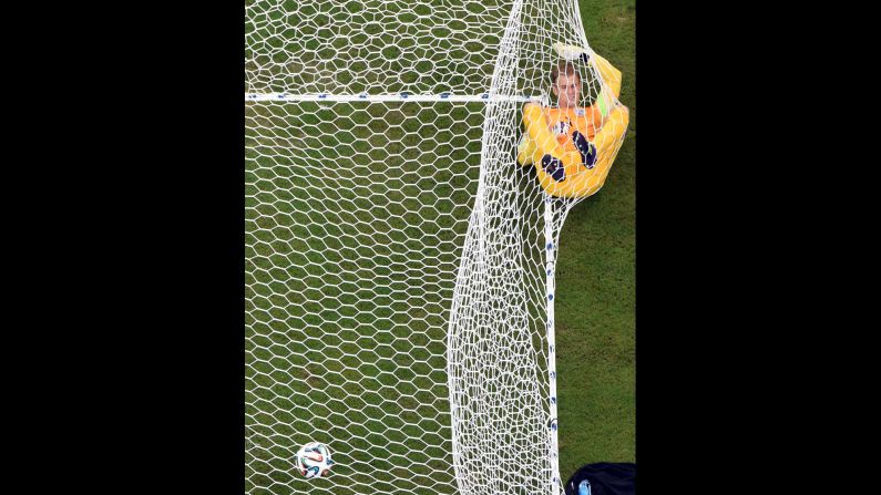 England's goalkeeper Joe Hart lies in the net after Mario Balotelli put Italy 2-1 up in the World Cup match at the Amazonia Arena in Manaus, Brazil.