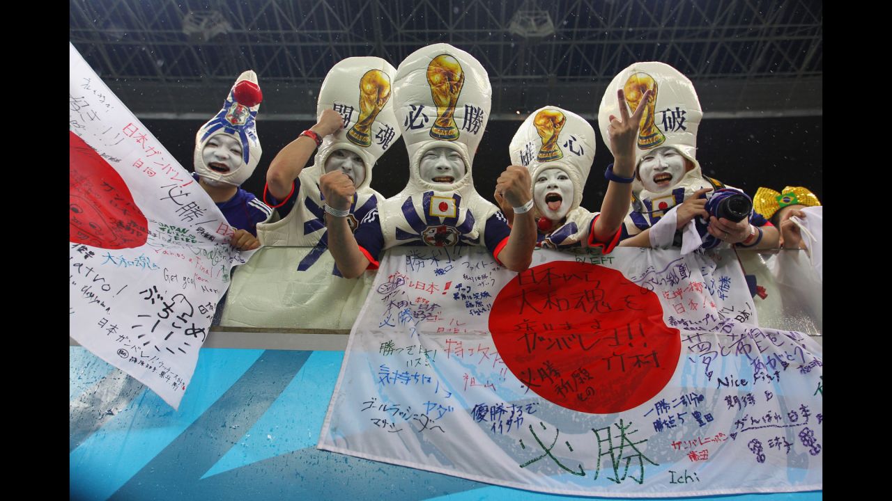  Japan fans proudly display flags and cheer during the match. 