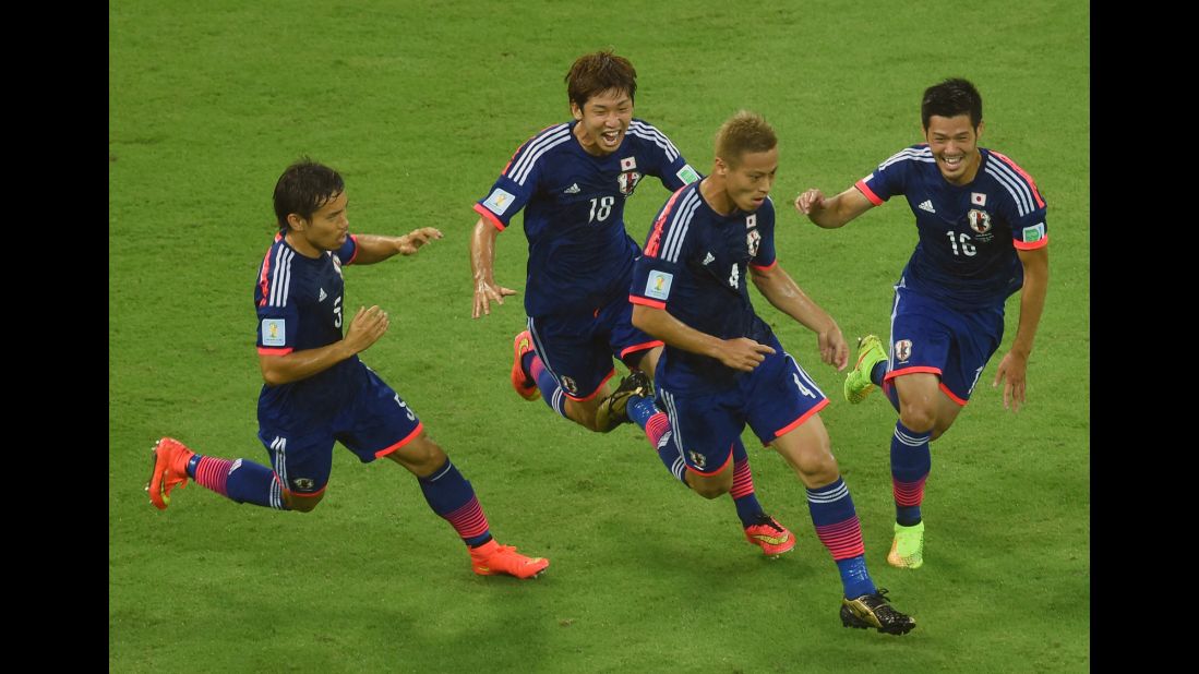 Keisuke Honda of Japan, second from right, celebrates scoring his team's first goal with Yuto Nagatomo, left, Yuya Osako, second from left, and Hotaru Yamaguchi, right