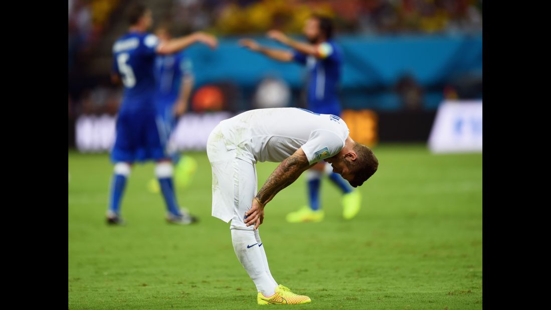  A dejected Jack Wilshere of England looks down as Italy celebrates the win.