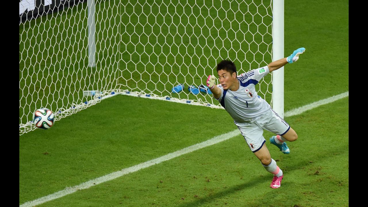 Japanese goalkeeper Eiji Kawashima tries in vain to stop a Wilfried Bony header from going in for Ivory Coast's first goal. 