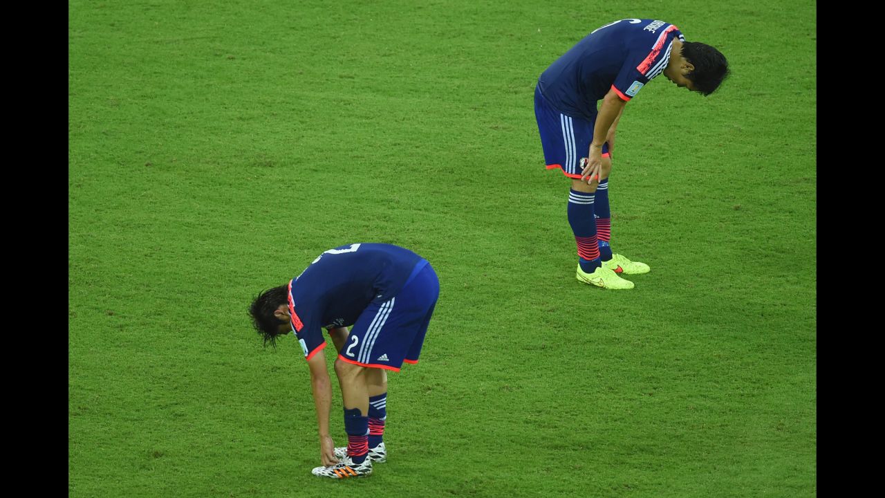 Japan players hang their heads after tough loss to Ivory Coast. 