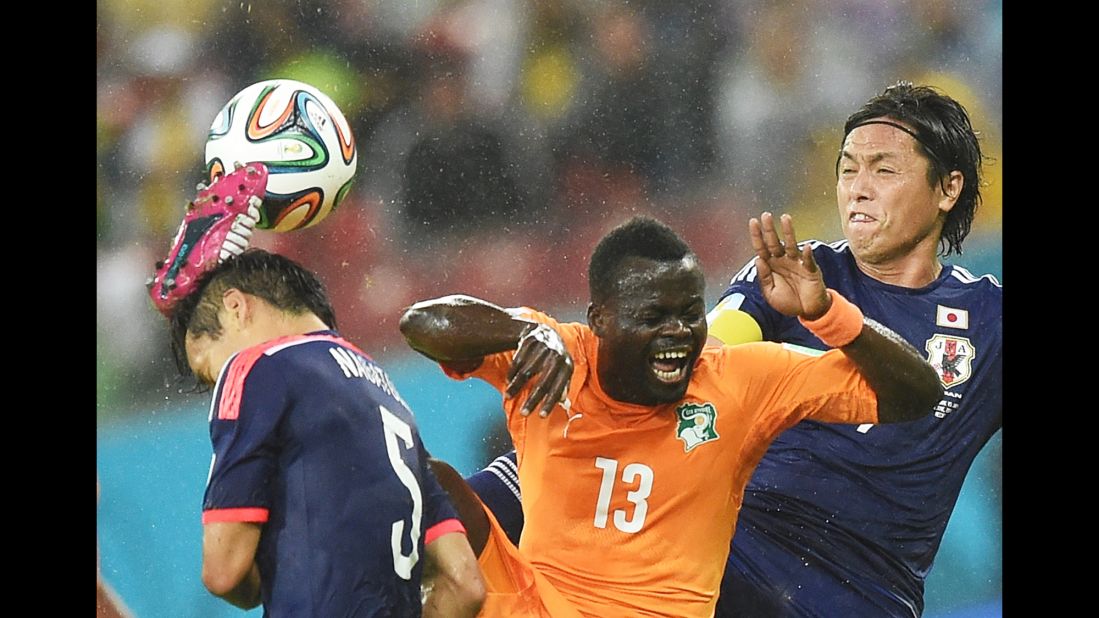 Ivory Coast midfielder Didier Ya Konan vies with a couple of Japan players for control of  the ball.