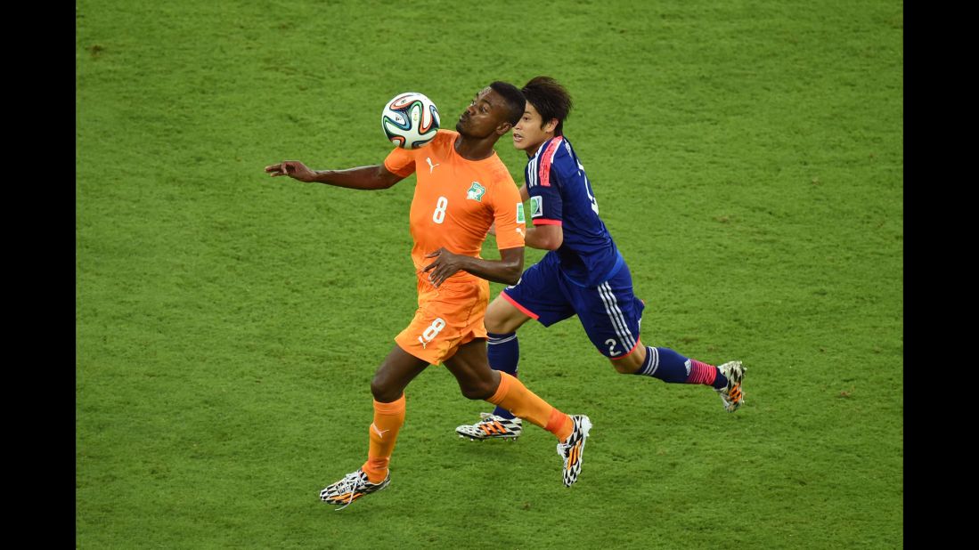 Salomon Kalou of the Ivory Coast controls the ball against Atsuto Uchida of Japan.