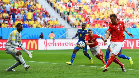 Substitute Haris Seferovic scores Switzerland's winning goal against Ecuador, beating goalkeeper Alexander Dominguez in the third minute of extra time to secure a 2-1 victory in the Group E opener June 15 in Brasilia, Brazil.