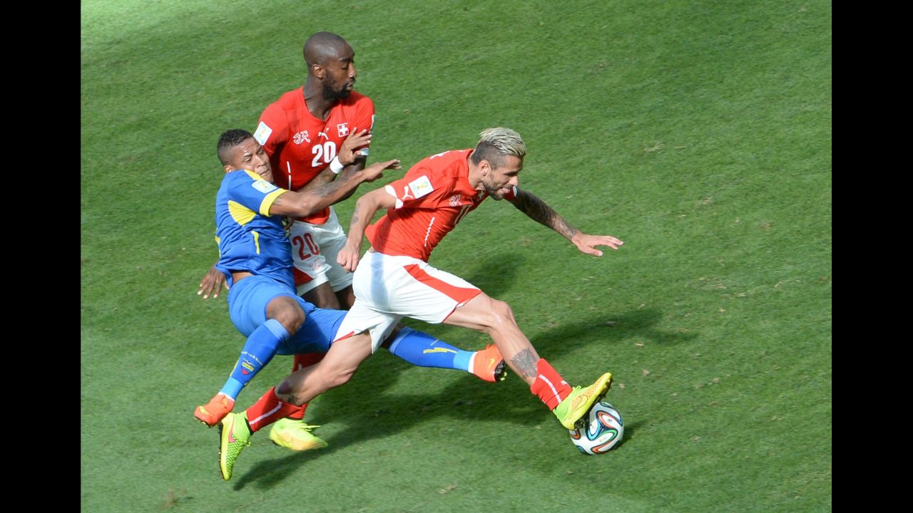 Switzerland midfielder Valon Behrami, right, is tackled by Ecuador's Michael Arroyo, left.