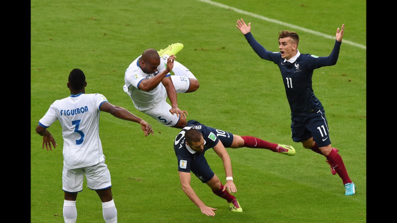 Honduras defender Victor Bernardez, center, falls over France forward Karim Benzema.