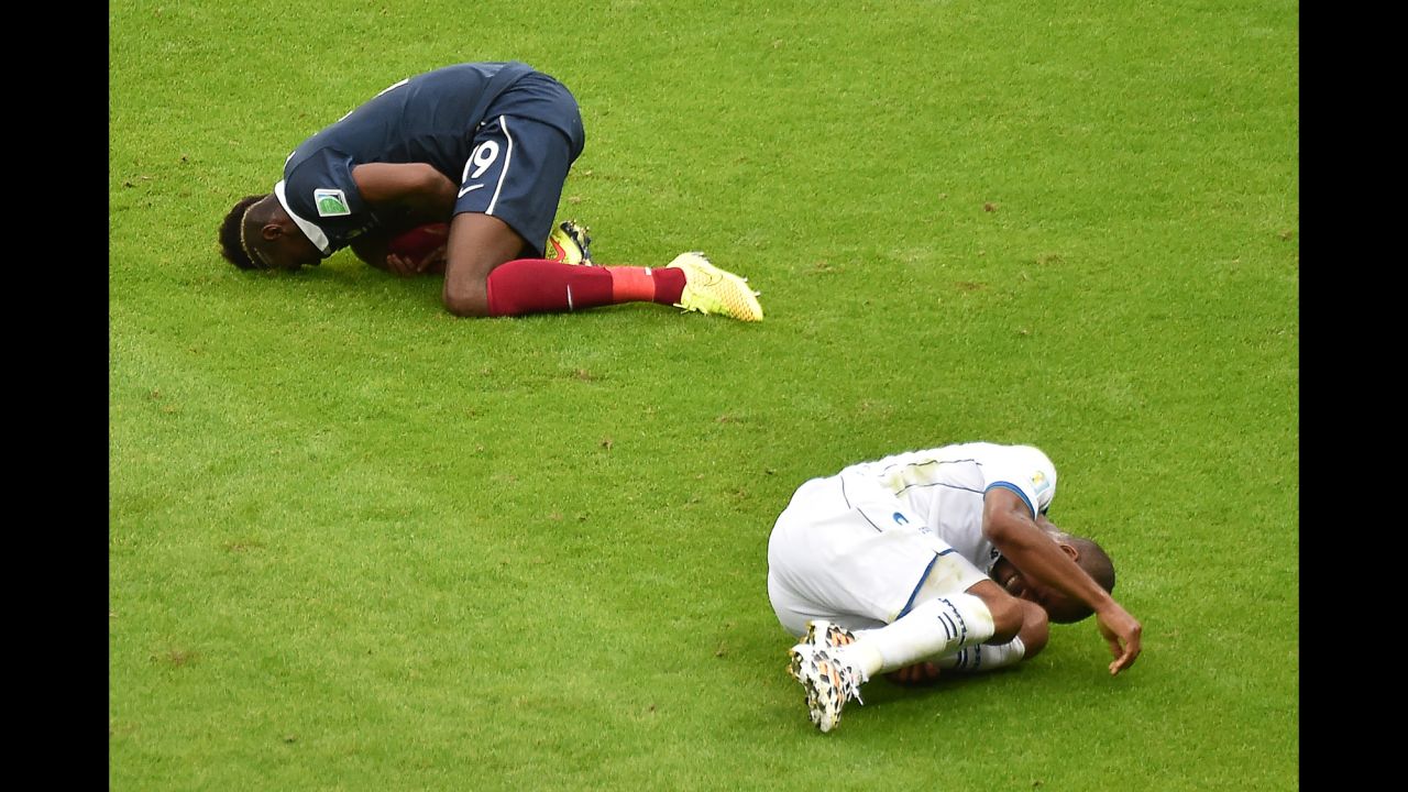 France midfielder Paul Pogba, left, and Honduras' Wilson Palacios fall after a tackle.