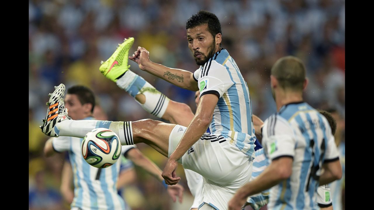 Argentina defender Ezequiel Garay jumps to kick the ball.