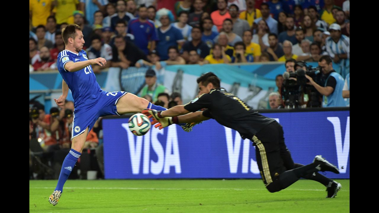 Bosnia-Herzegovina midfielder Izet Hajrovic fights for the ball with Argentina's goalkeeper Sergio Romero.