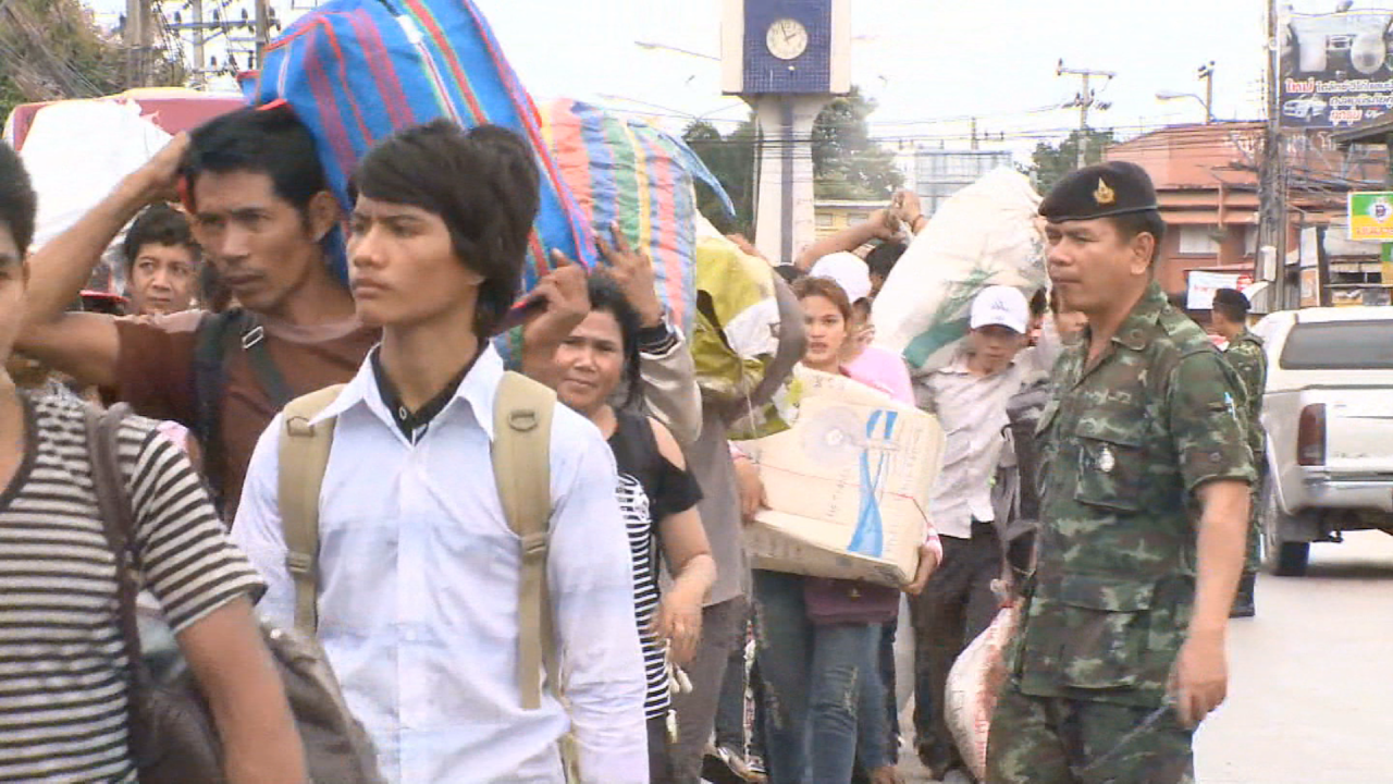 Streams of Cambodian workers head to a train station.