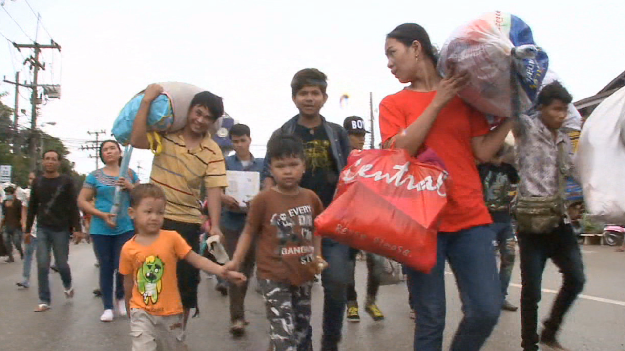 Cambodian workers gathered their belongings and their children to make the journey back to their home country. 