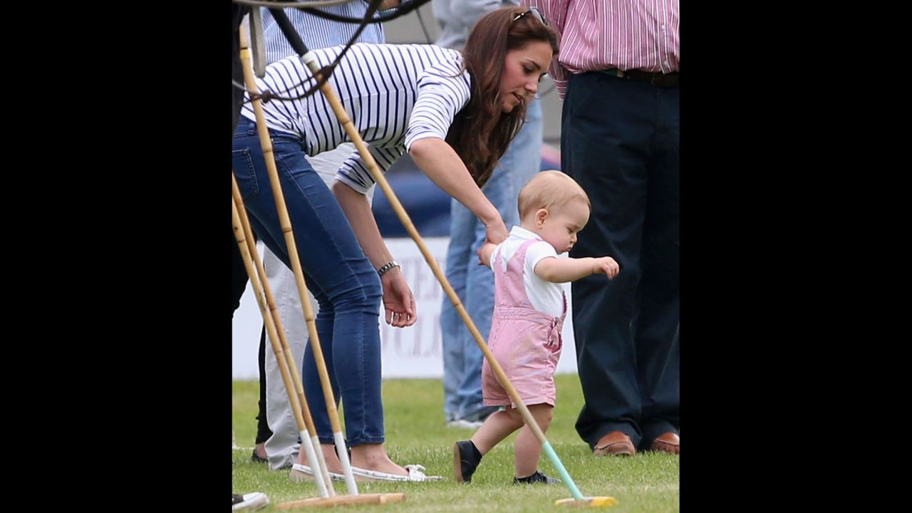 Prince George takes his first steps in public as his mother, Catherine, Duchess of Cambridge, holds his hand Sunday, June 15, at a charity polo event in Cirencester, England.