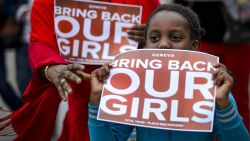 A young participant shows a placard during a demonstration in Geneva on May 10, 2014 in support of the abducted Nigerian school girls and their families. 