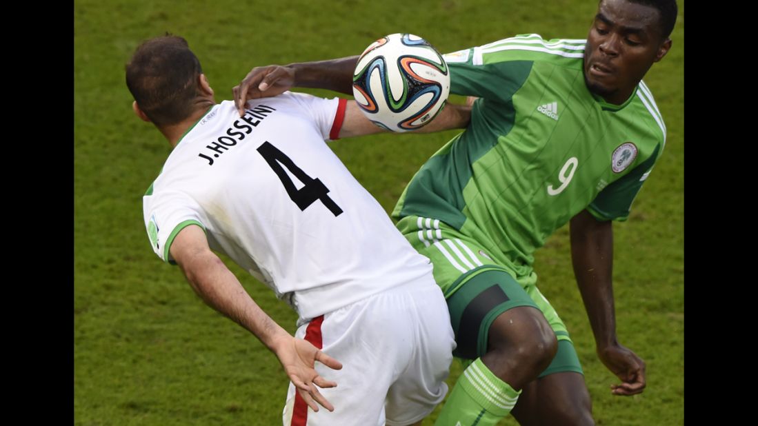 Iran's Jalal Hosseini fights for the ball with Emenike.