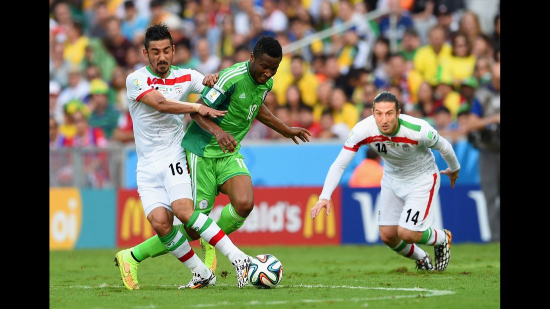 John Obi Mikel of Nigeria, center, tries to tackle Iran's Reza Ghoochannejhad.