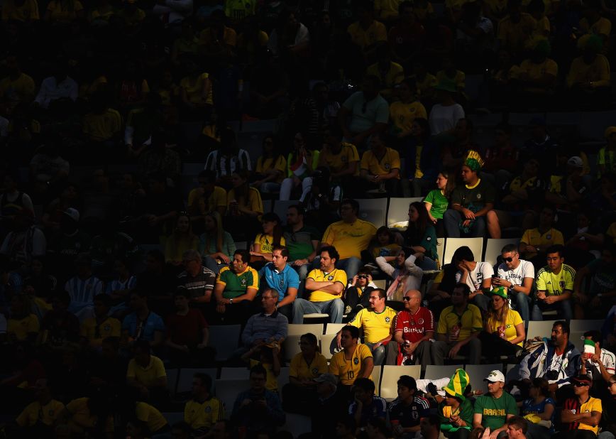 Fans look on from a spot of sunlight during the match between Iran and Nigeria.