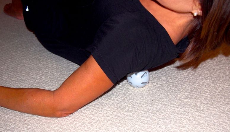 Lay on the floor with the ball under your shoulder blade. Slowly rock yourself back and forth over the ball, moving it around the large muscles encasing the blade. 