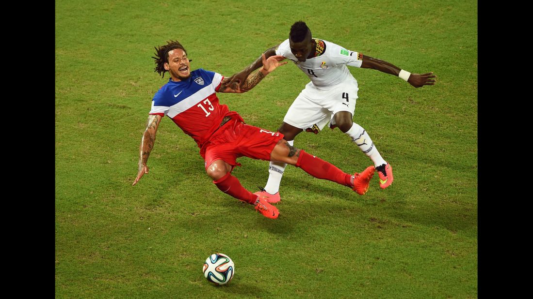 Jermaine Jones of the United States falls after a challenge from Ghana's Daniel Opare.
