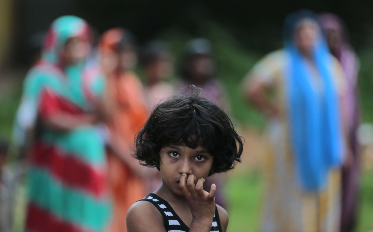 A girl looks at a burned house in Aluthgama.