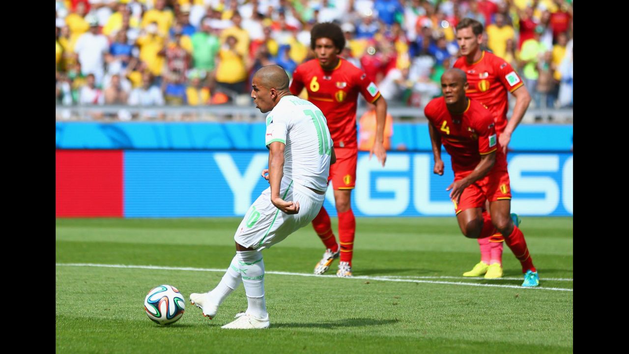 Sofiane Feghouli scores on a penalty kick to give Algeria a 1-0 lead. 