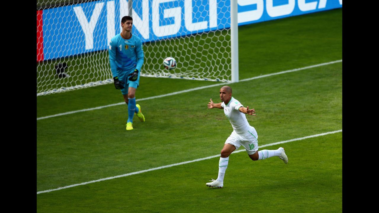 Feghouli runs to the corner of the field after his penalty kick beat Belgian goalkeeper Thibaut Courtois.
