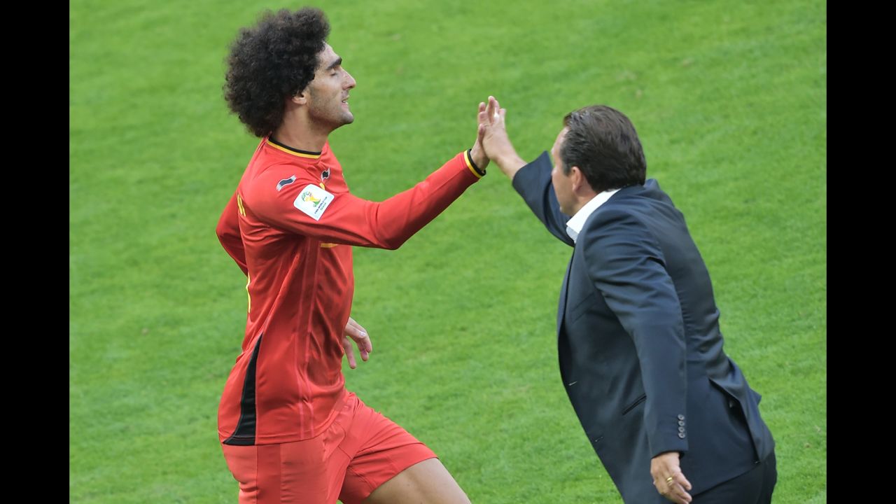 Belgian midfielder Marouane Fellaini high-fives his coach, Marc Wilmots, after scoring his team's first goal with a header.