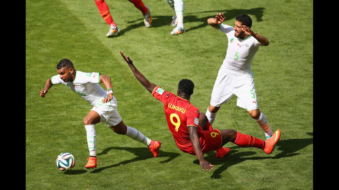 El Arabi Soudani of Algeria dribbles past Belgium's Romelu Lukaku.