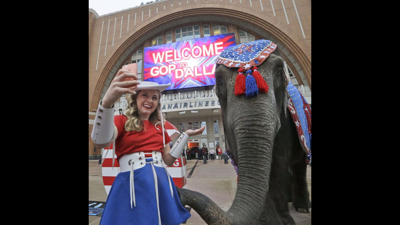 A Kilgore College Rangerette takes a selfie with an elephant in front of the American Airlines Center in Dallas, which was hosting members of the Republican National Committee on Thursday, June 12. The committee is scouting possible sites for the 2016 Republican National Convention.