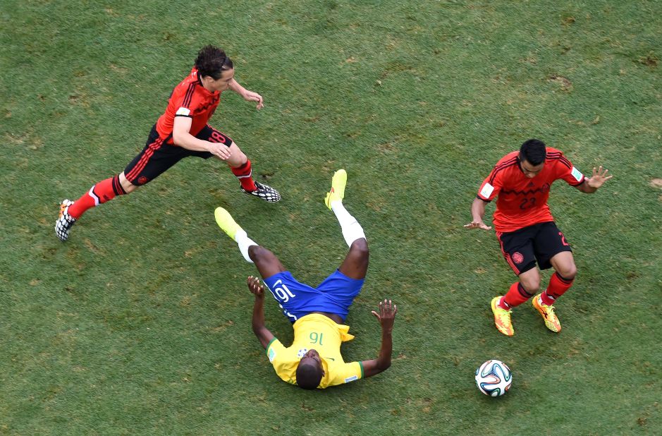 Ramires of Brazil falls after a challenge by Guardado, left, and Vazquez.