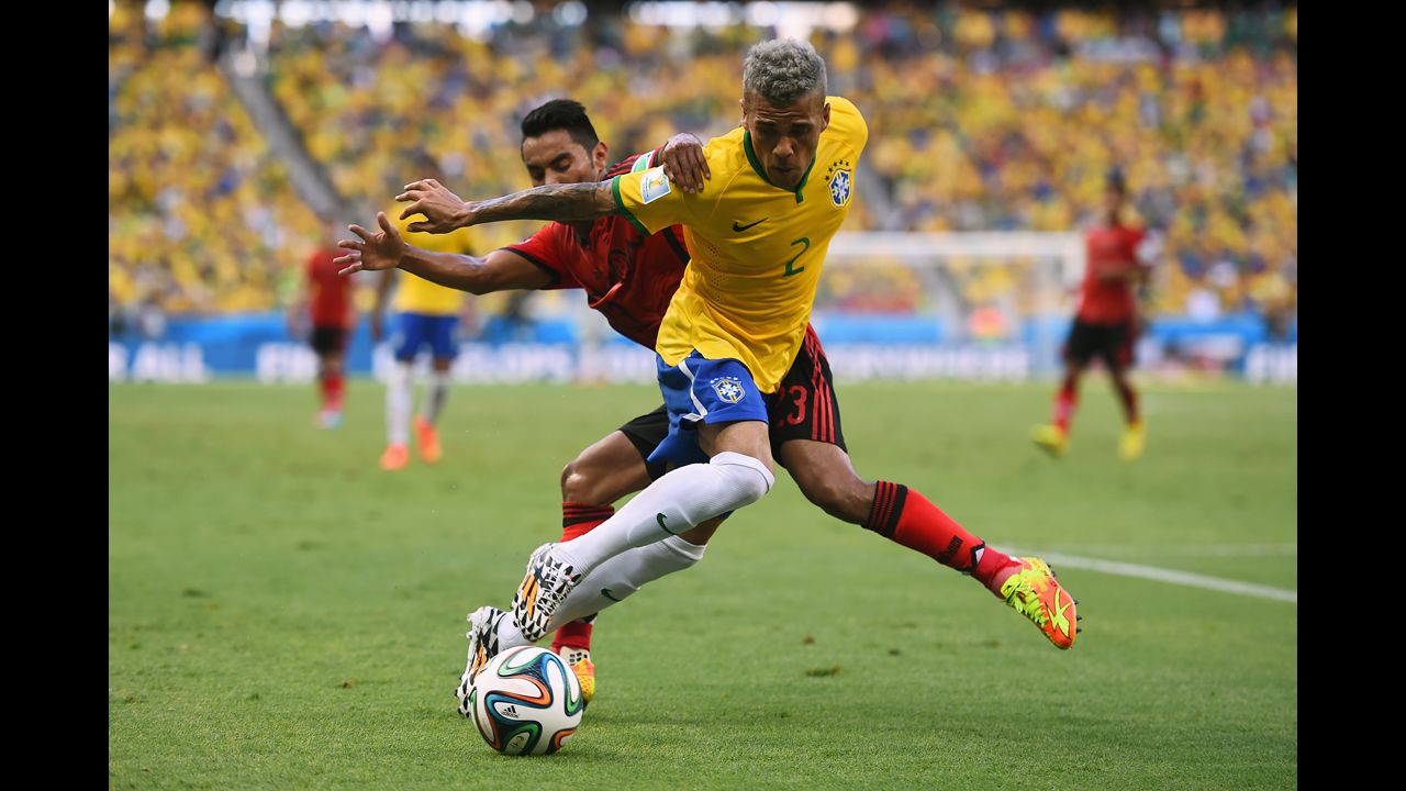 Dani Alves of Brazil, front, and Vazquez battle for the ball.