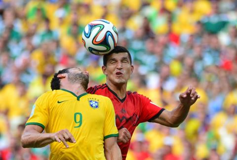 Brazilian forward Fred, left, vies for the ball with Mexican defender Francisco Rodriguez.