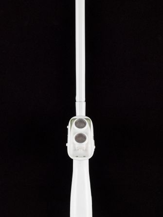 The device attaches to a standard white cane. It emits ultrasound waves to detect nearby obstacles and vibrates to inform the user avoid them.