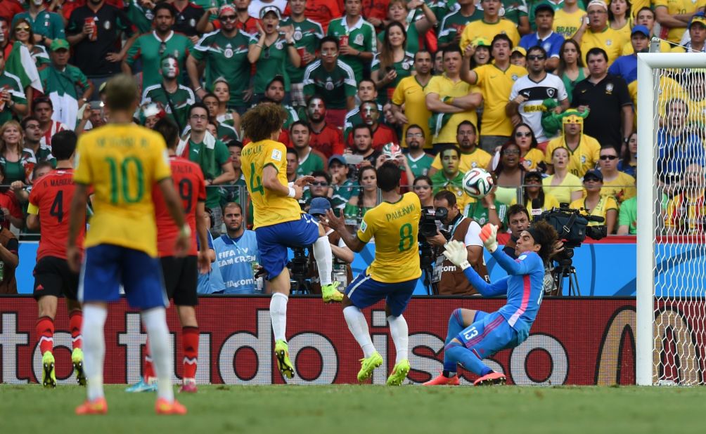 Mexican goalkeeper Guillermo Ochoa, right, makes a save near Brazilian players David Luiz and Paulinho during a World Cup match in Fortaleza, Brazil. The match ended 0-0 in large part to Ochoa, who made several key saves.