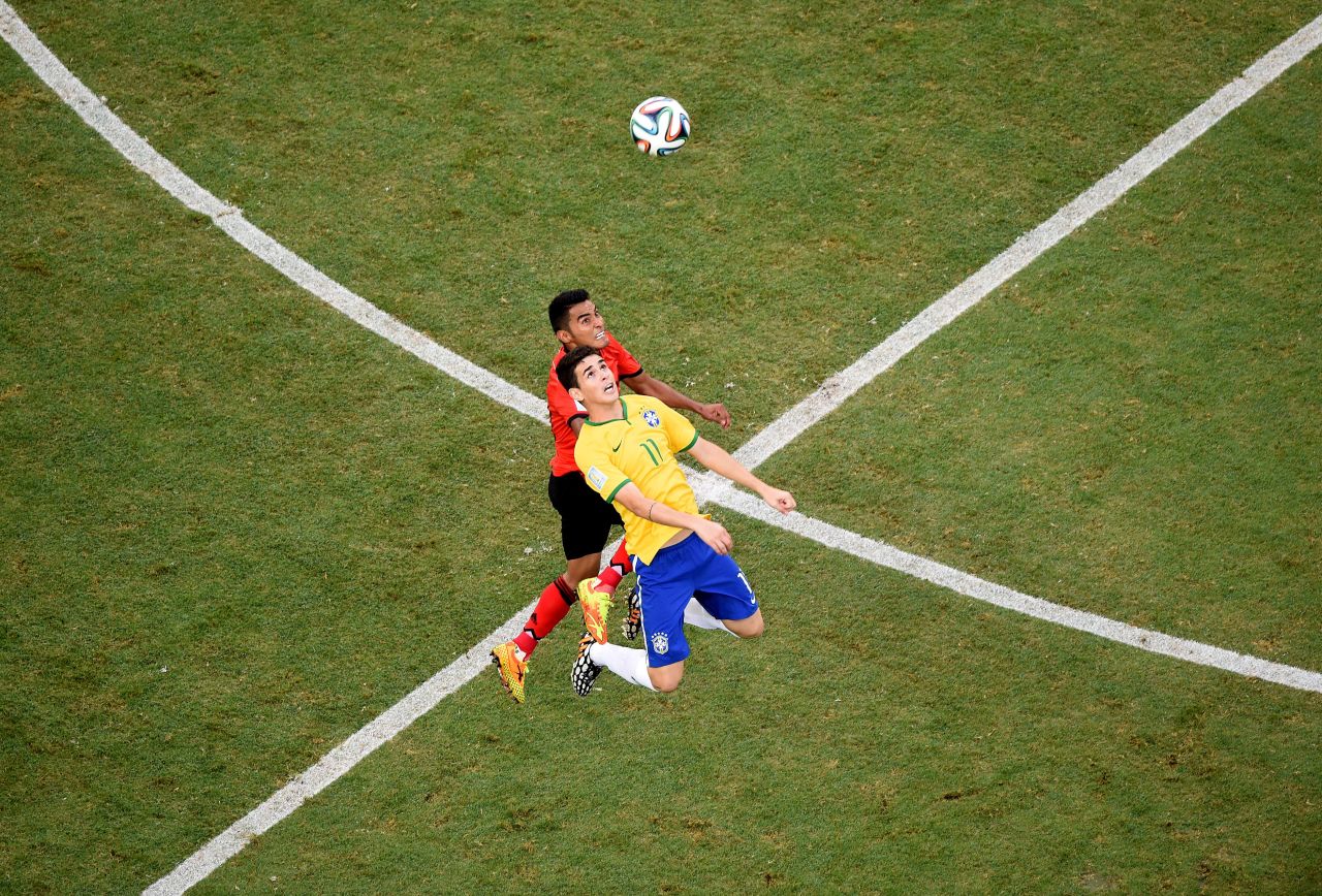 Mexican midfielder Jose Juan Vazquez, left, competes for the ball with Brazil's Oscar.