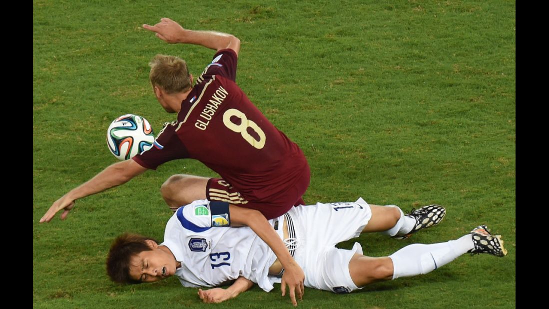South Korean forward Koo Ja-Cheol, bottom, vies with Russian midfielder Denis Glushakov.