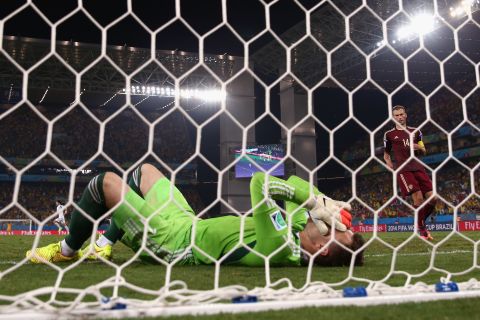 Igor Akinfeev of Russia lies in the net after failing to stop Lee from scoring.