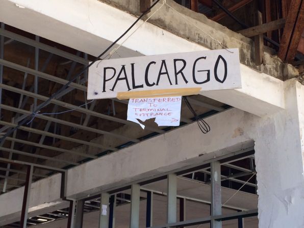A hand-written sign pointing travellers to the Philippines Airlines Cargo area. 