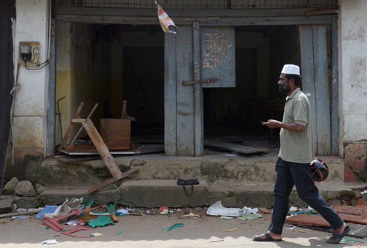 A Sri Lankan Muslim man walks past ransacked shops in Aluthgama.