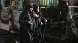 Iraqi women walk at the site of a car bomb explosion in the mainly Shiite Sadr City district in Baghdad on June 18, 2014 which killed at least seven people and wounded 20.