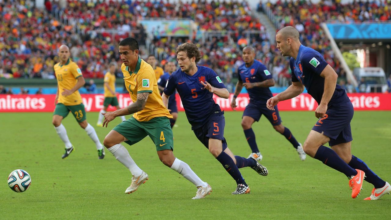 Australia's Tim Cahill dribbles past Dutch players. Cahill had a tremendous volley in the first half to tie the game at 1-1.